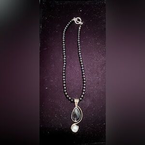 Black beaded costume necklace with synthetic pearl pendant.